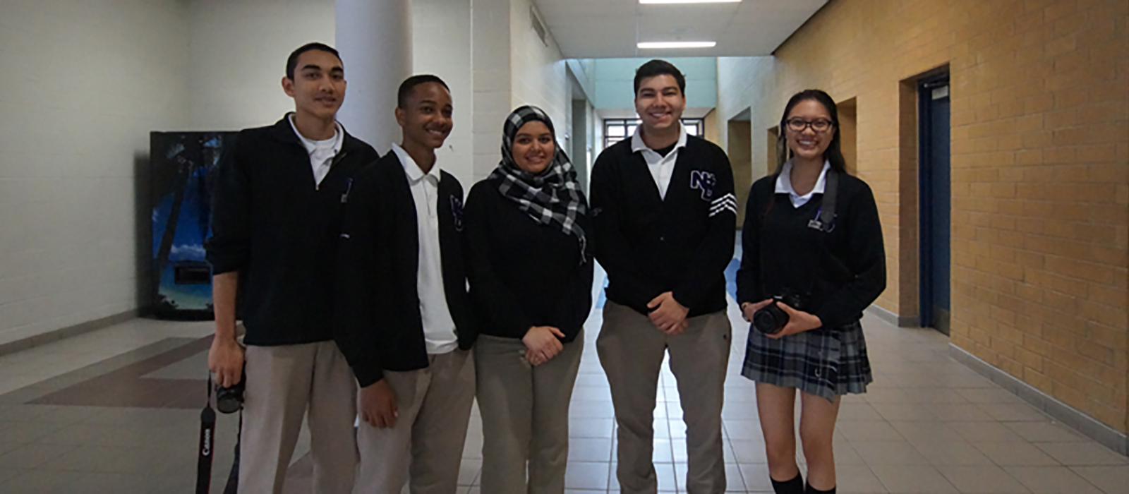 Male and female student leaders standing in a hallway